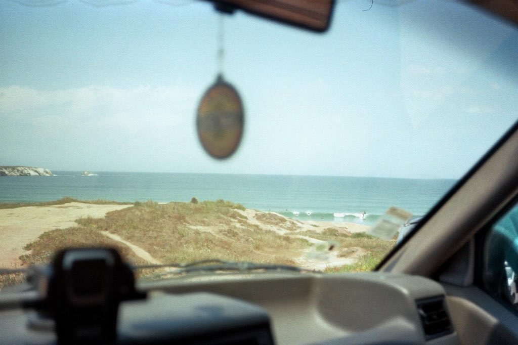 View of surfers and the sea from inside a vintage camper van